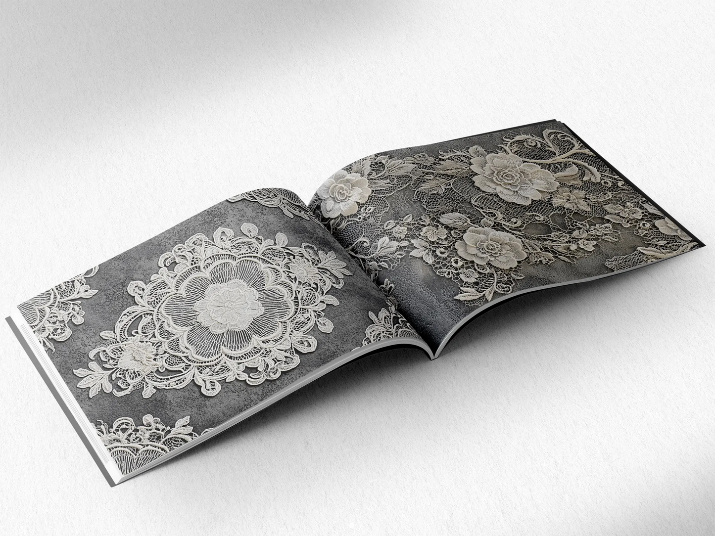 open book displaying the inner pages of a decorative paper prints pad showing grey doilie lace patterns