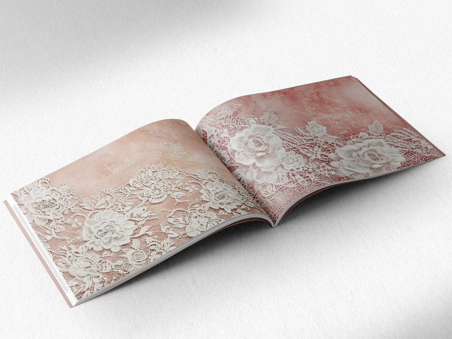 open book displaying the inner pages of a decorative paper prints pad showing pink doilie lace patterns