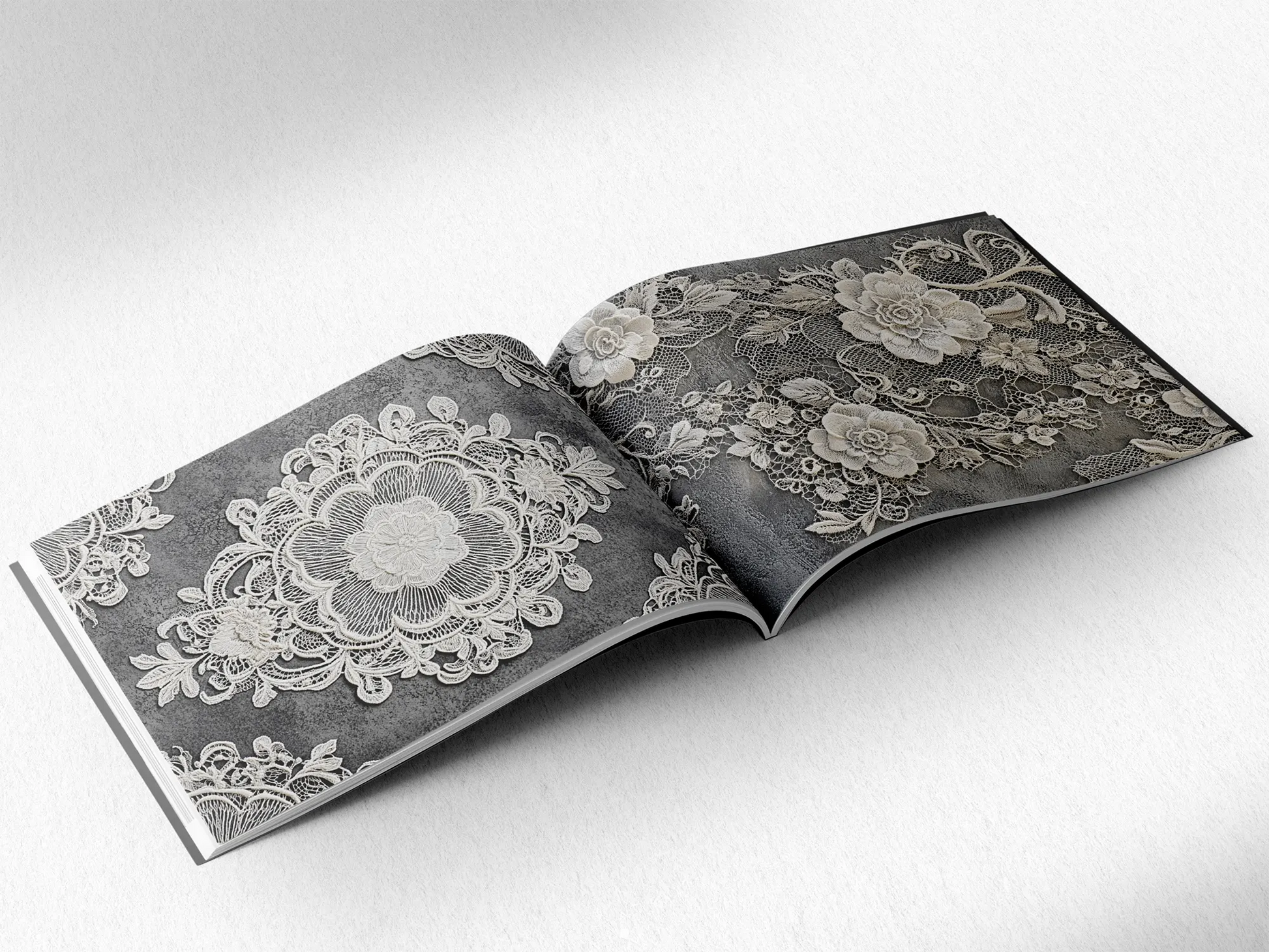 open book displaying the inner pages of a decorative paper prints pad showing grey doilie lace patterns